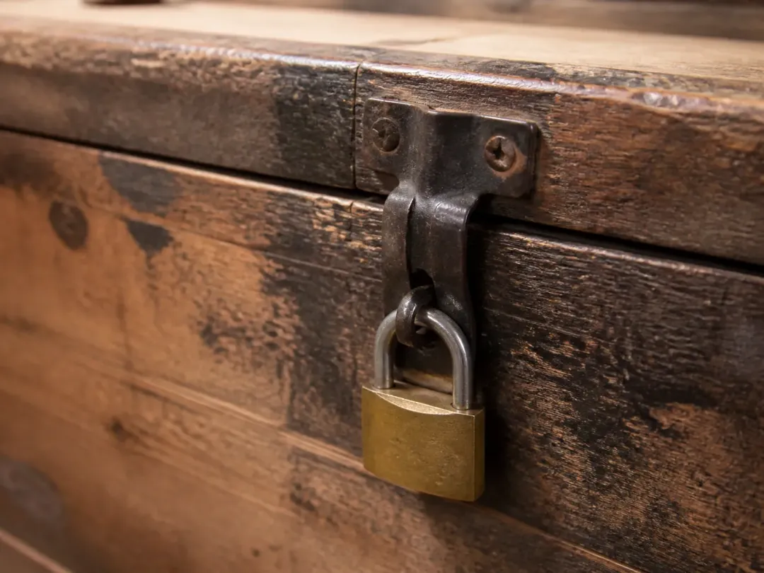 Cadenas en laiton fermé sur le moraillon d’une caisse en bois