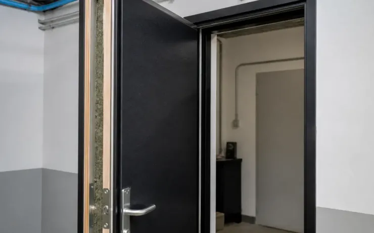 Porte ouverte avec matériaux pour isolation phonique visible dans un couloir industriel